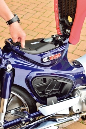 ホンダ・スーパーカブC125のサイドカバーはボタンでオープン