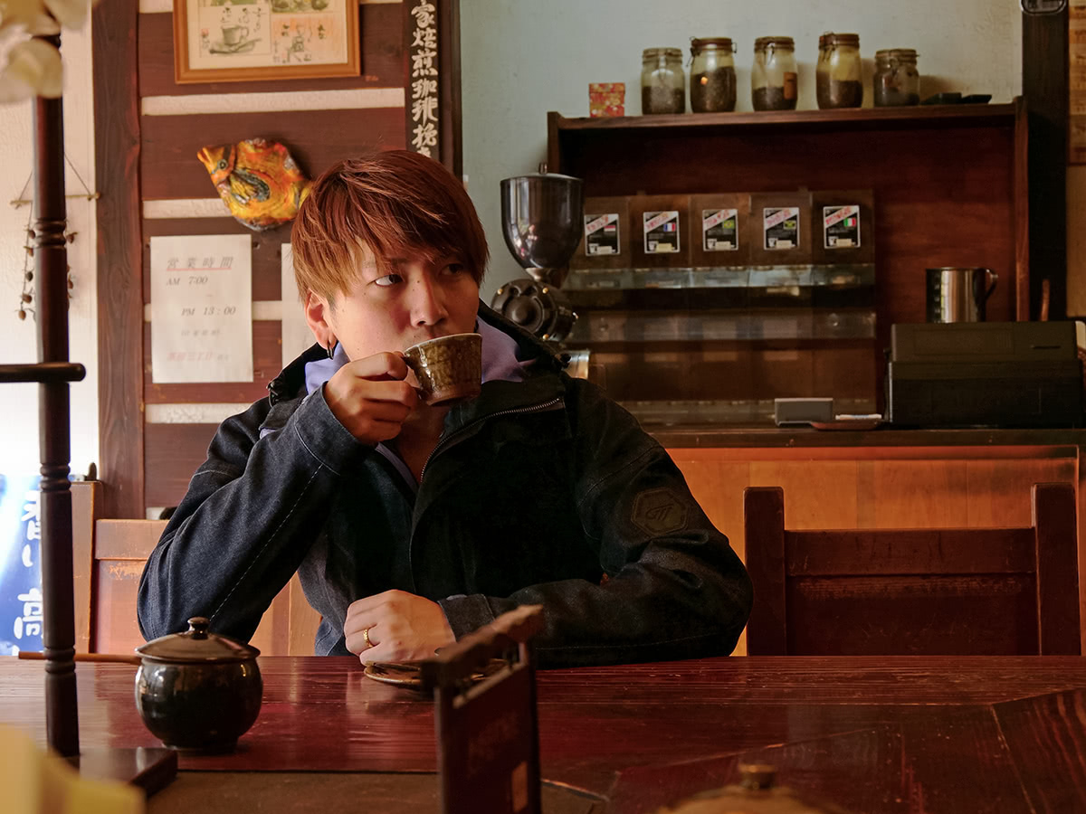 GOLDWIN MOTORCYCLE GWM ゴアテックスデニムジャケットを着てカフェで一服するライダー